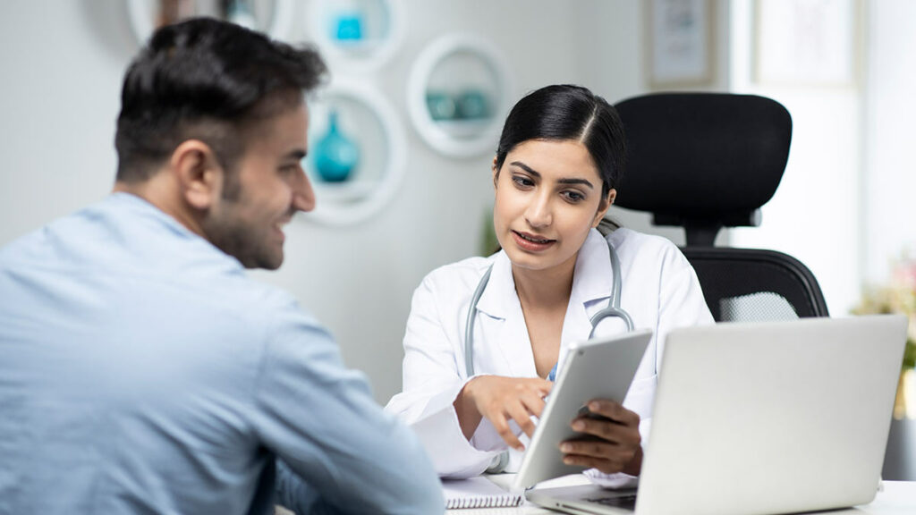 A doctor shows a patient information on a tablet device.