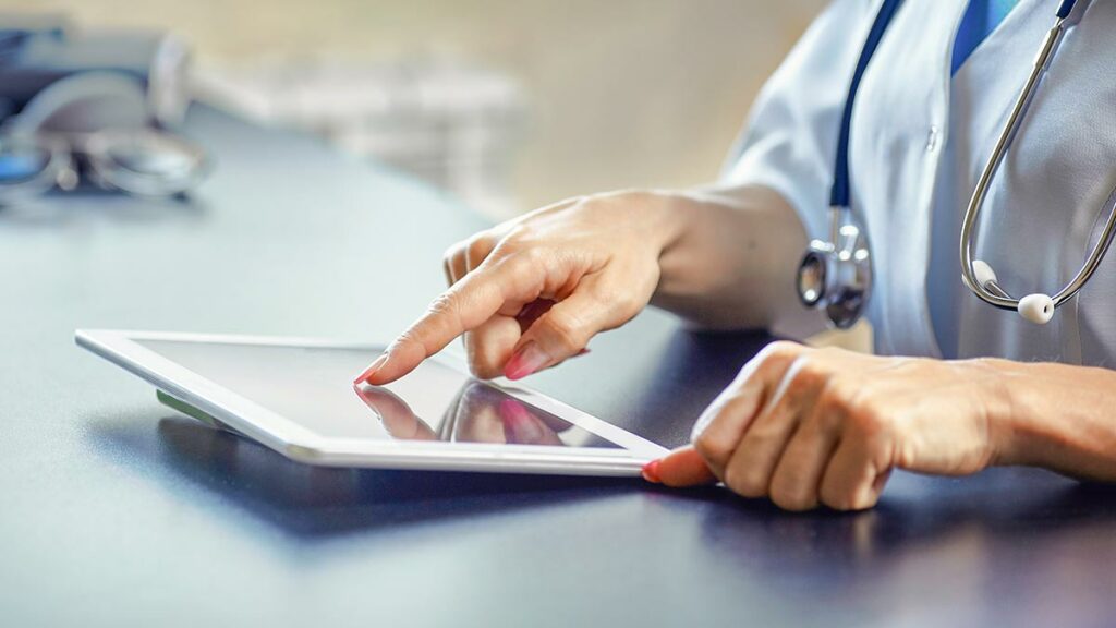 A doctor uses a tablet device.