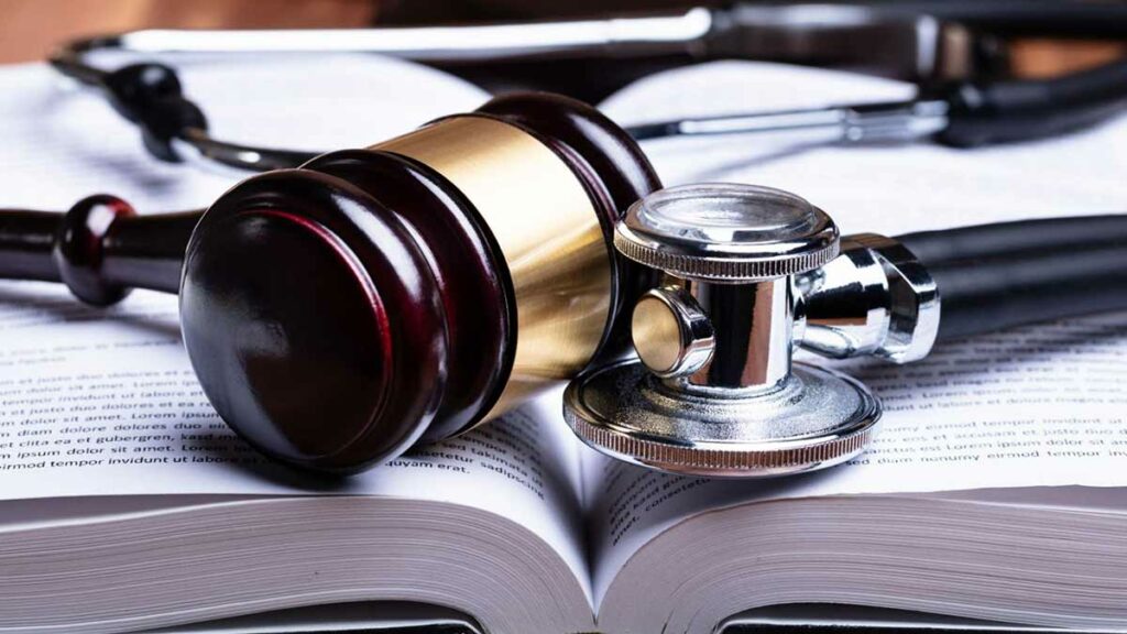 A judge’s gavel and a doctor’s stethoscope placed on a book.