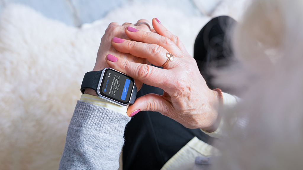 Woman looking at wearable medical smart watch device on her arm.