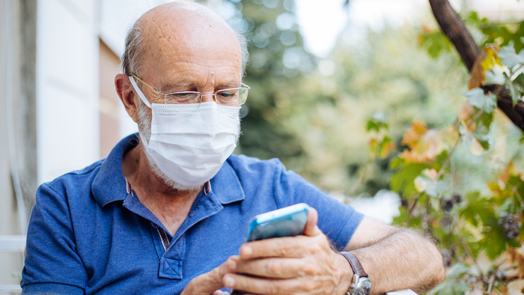 An elder clinical trial patient uses his smartphone to register his daily tasks.